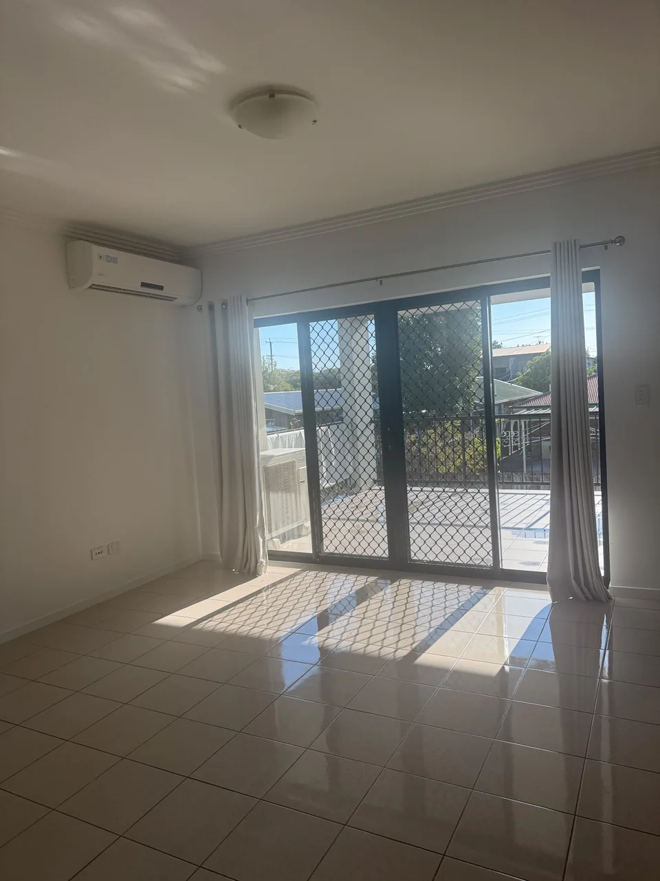Clean tiled living area with glass doors